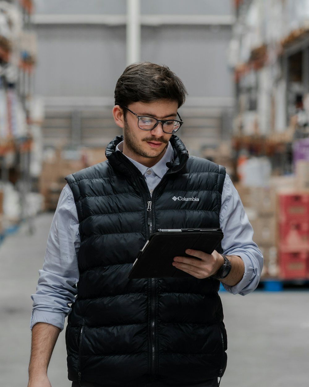Supervisor revisando inventario en una tableta dentro de un almacén